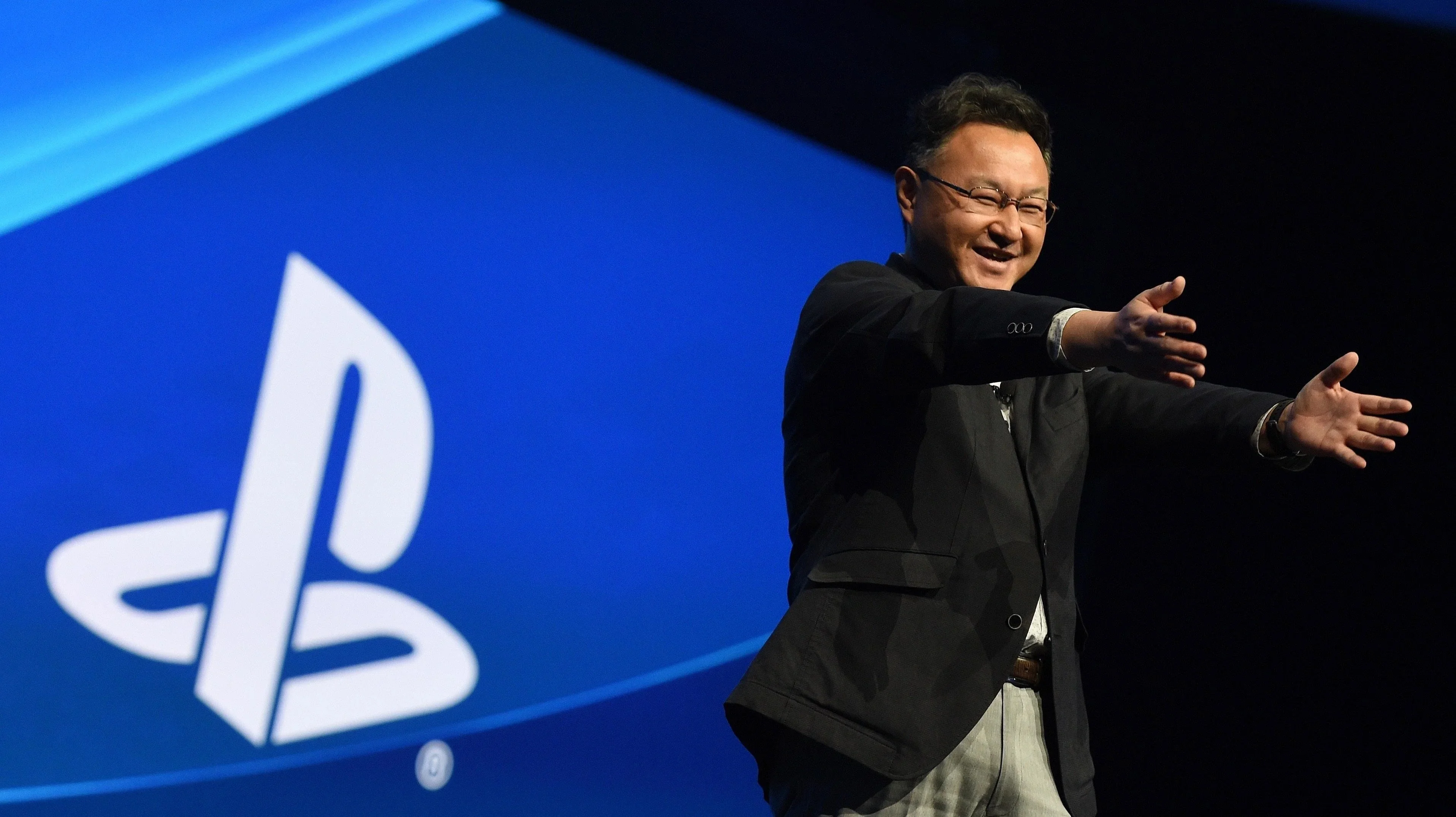 Сюхэй Ёсида на фоне логотипа PlayStation