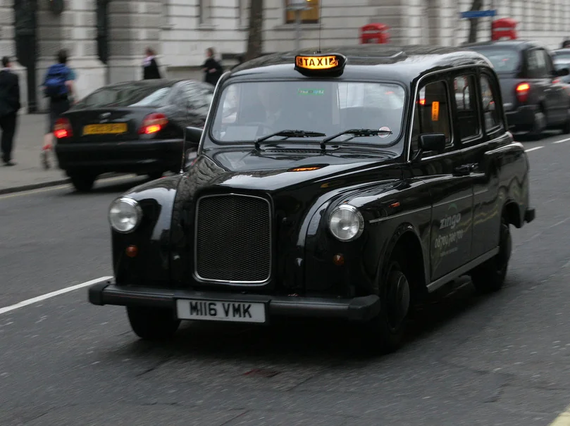 Лондонское черное такси Black Cab на фоне современного города