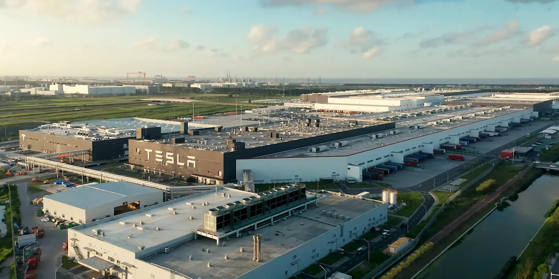 логотип Tesla на фоне шанхайского гигафактори