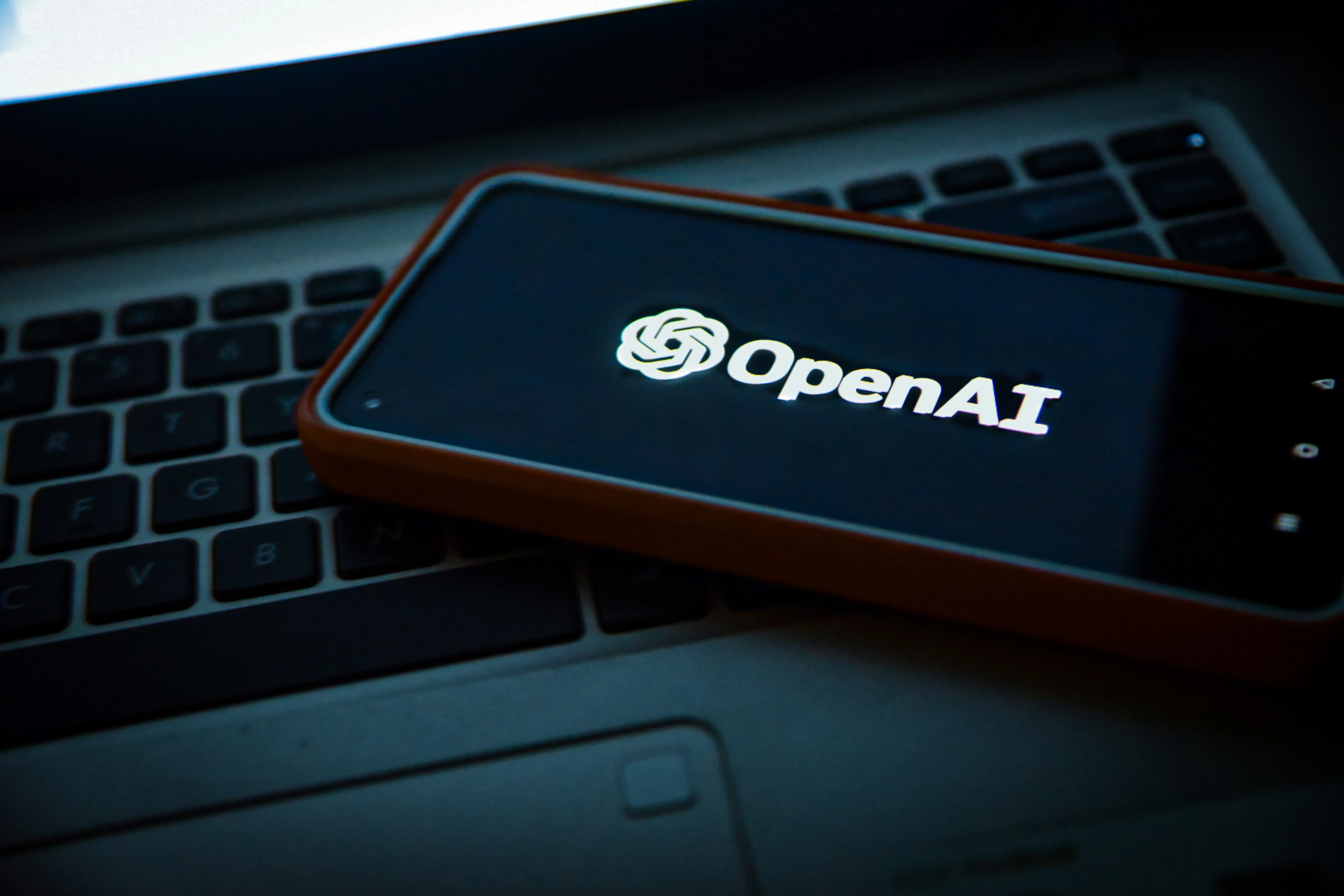 логотипы OpenAI и Android Authority на фоне смартфона